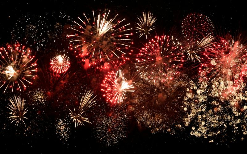 Red and gold fireworks bursting in night sky